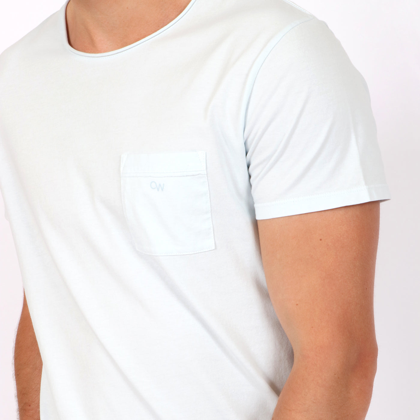 OWTS1804 Ice Blue garment dyed beach fit men's organic cotton t-shirt with chest pocket detail on body raw edge roll neck and pocket closeup